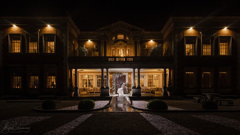 Bride and Groom pose at nigh at Eaves Hallt