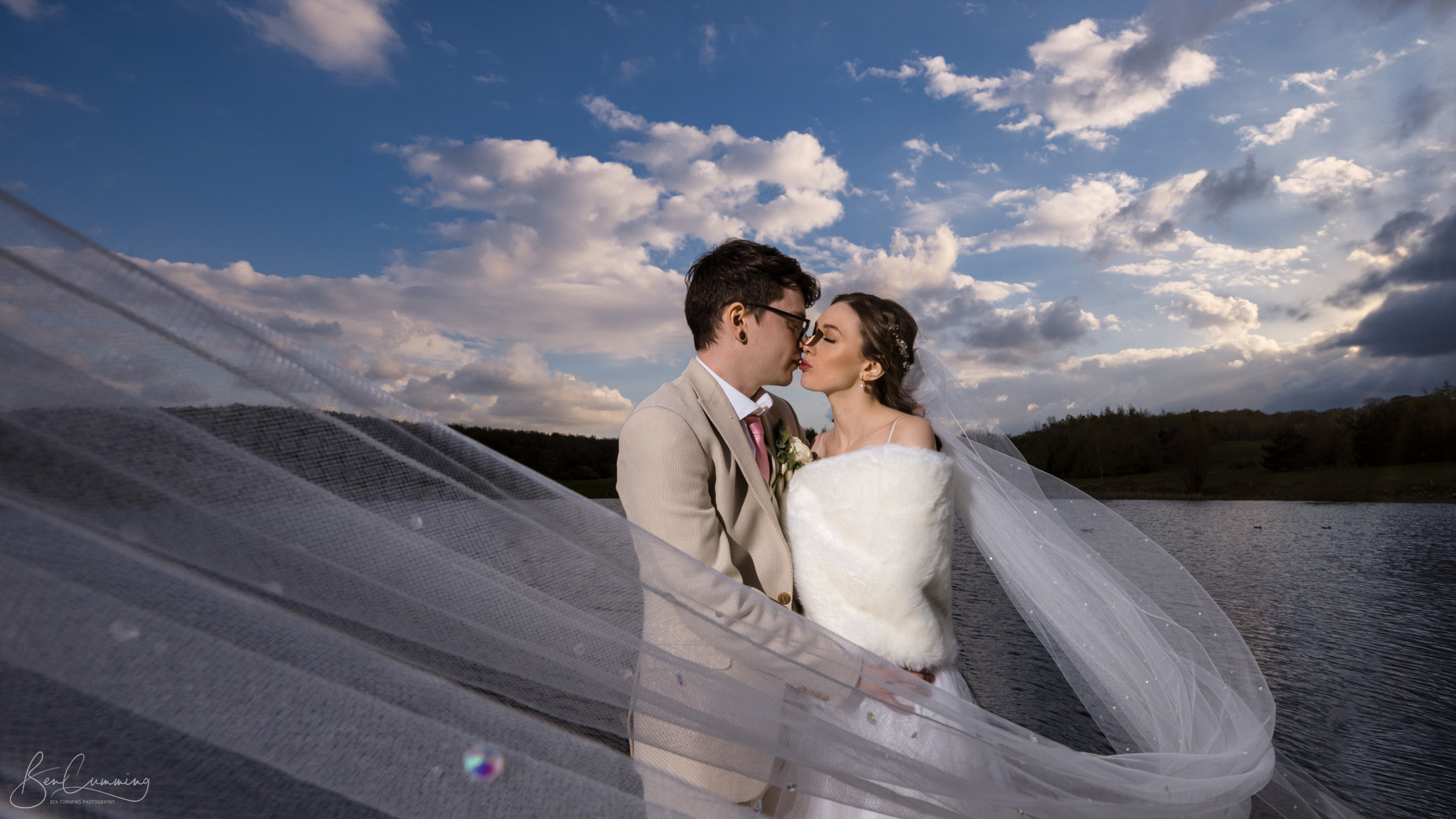 Bride and groom kiss on the decking of Waterton Park