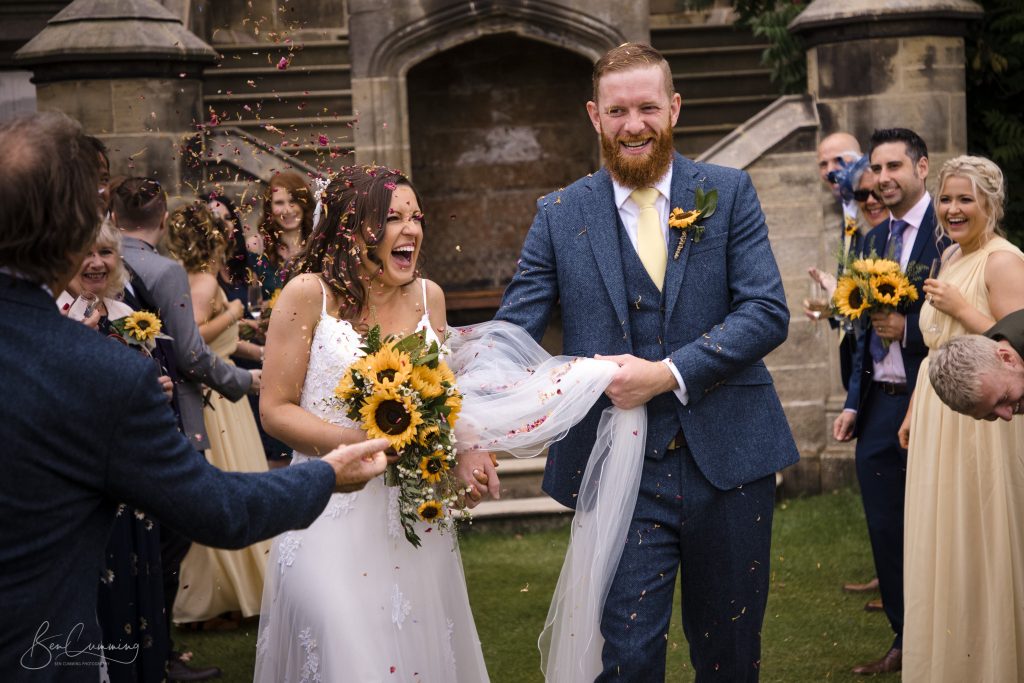 Bride and Groom Getting Covered in Confetti at Allerton Castle
