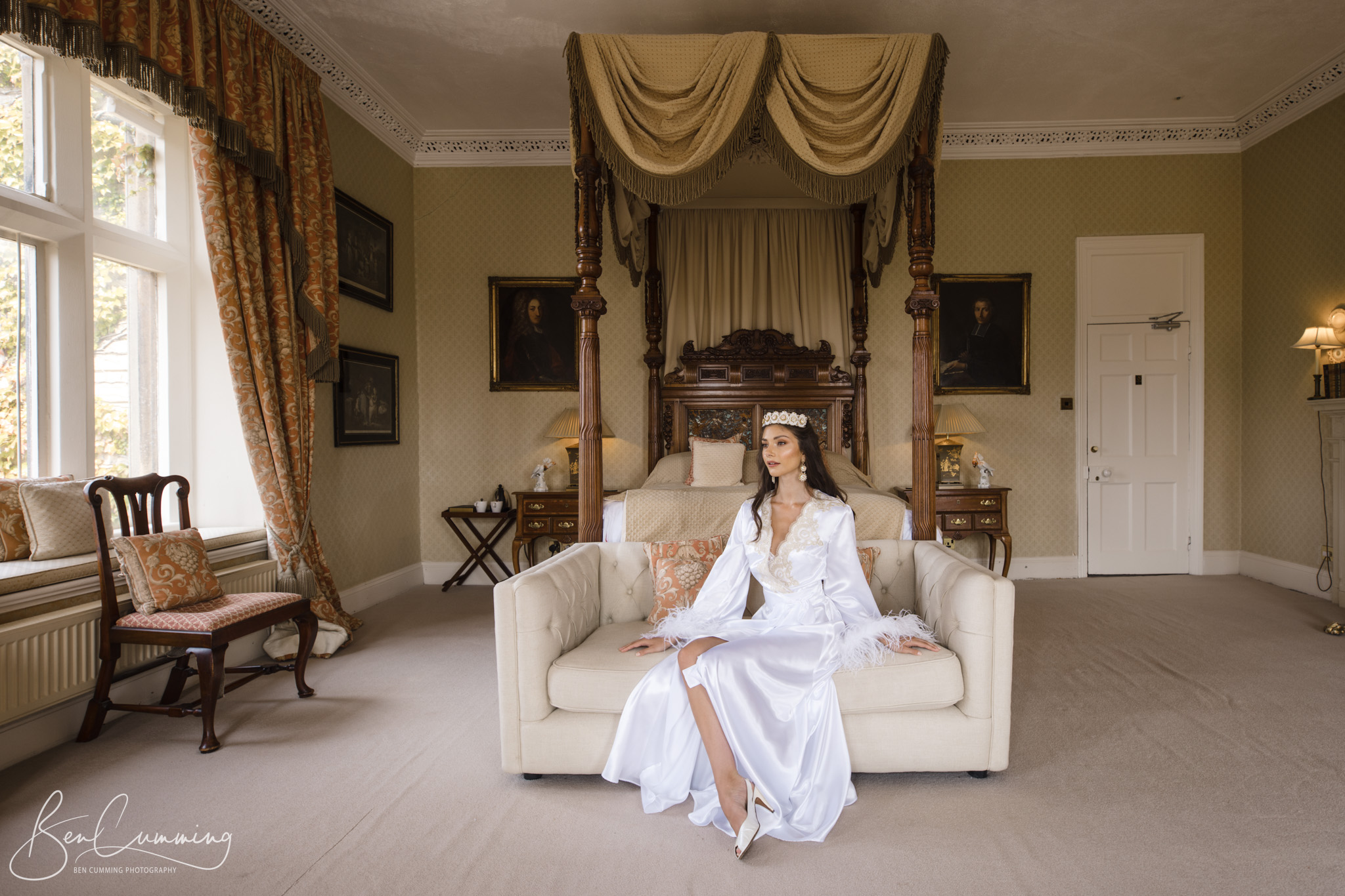 A bride in a white dress sitting on a couch in Carlton Towers.